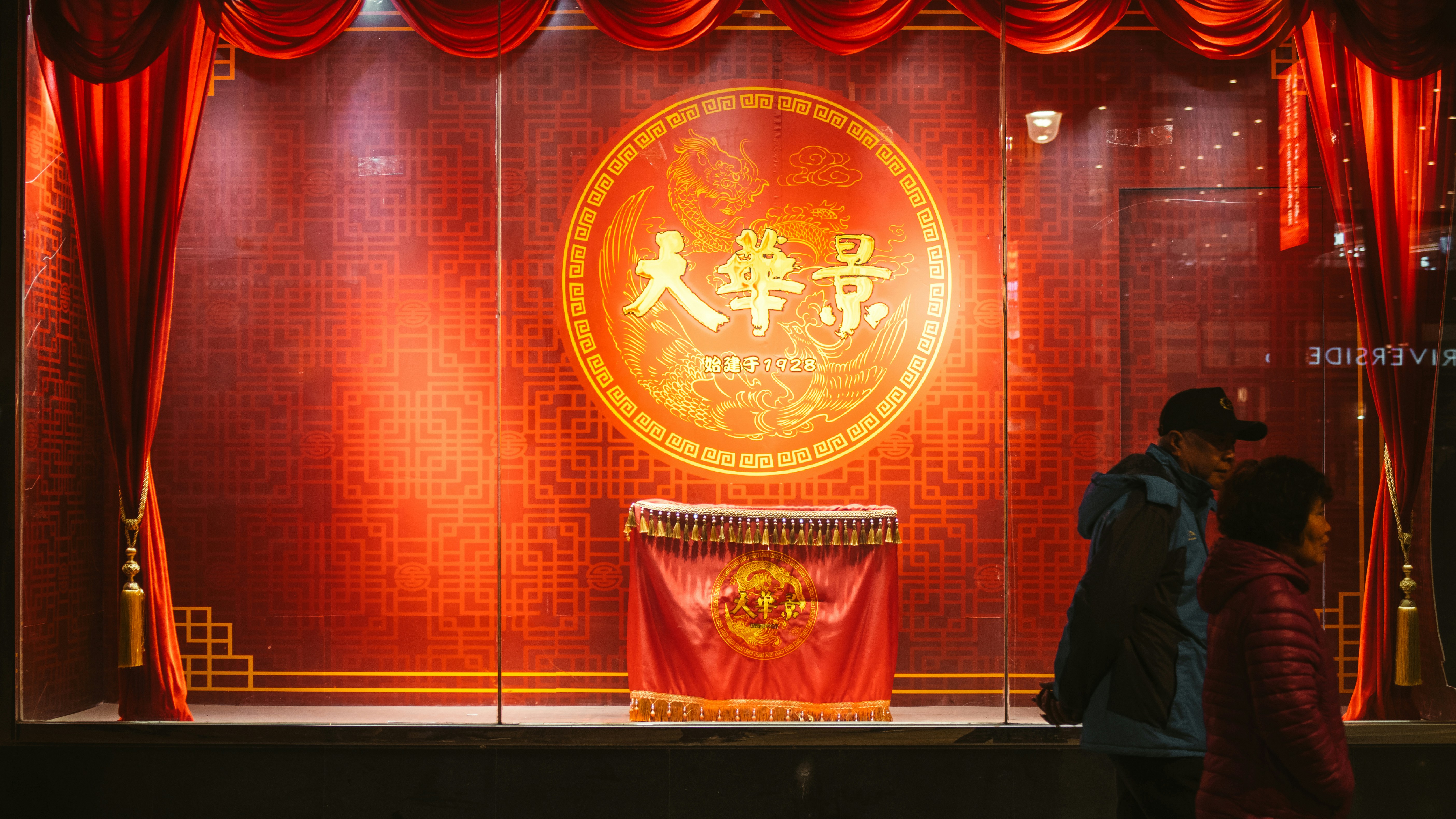 a couple of people standing in front of a red wall