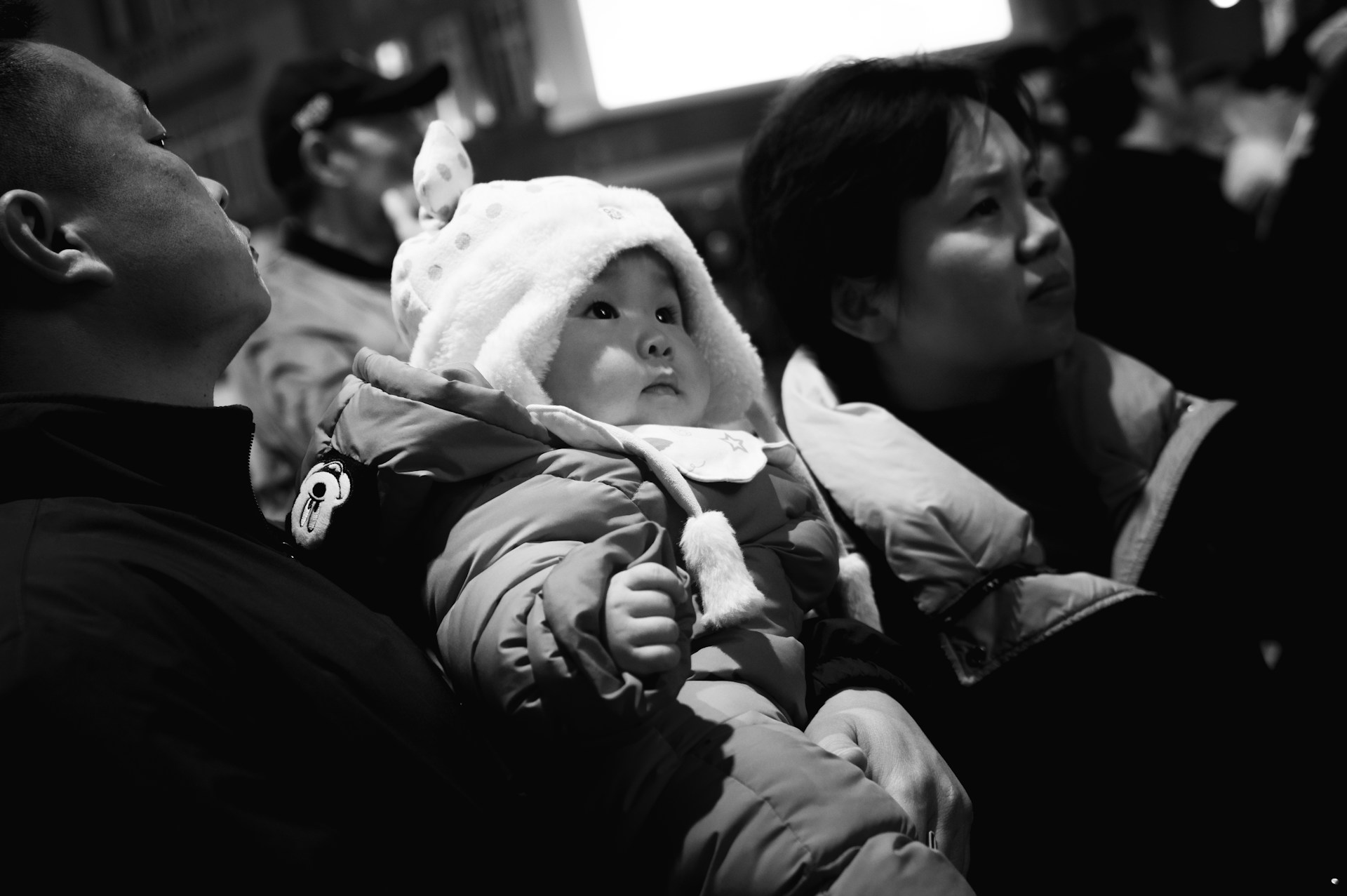 a black and white photo of a baby wearing a hat