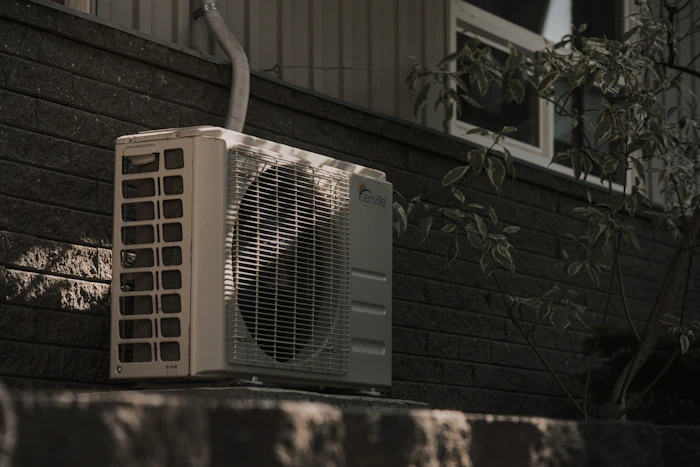 Outdoor condenser unit installed against a wall