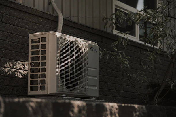a white air conditioner sitting on top of a brick wall