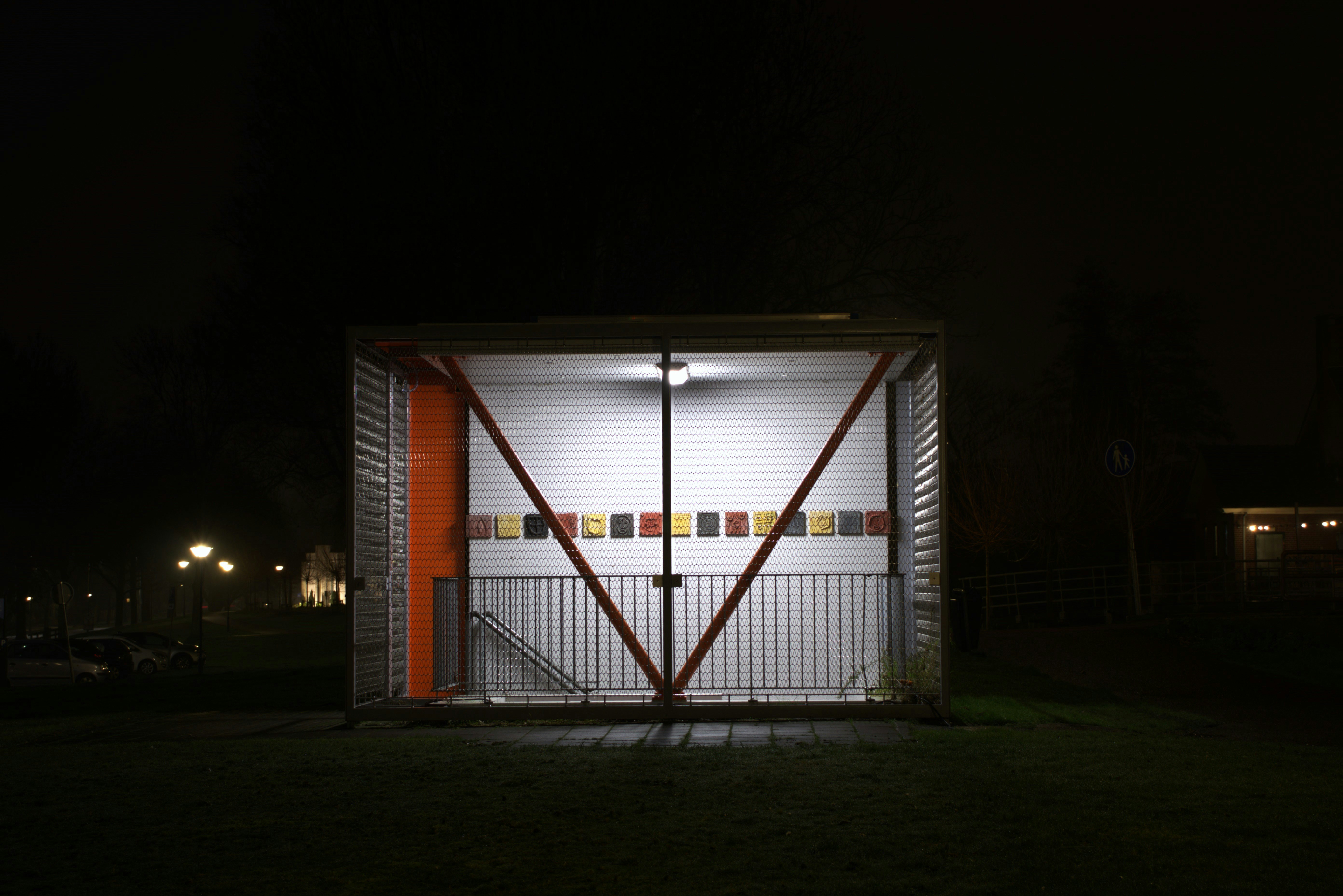 un pequeño cobertizo con una puerta abierta por la noche