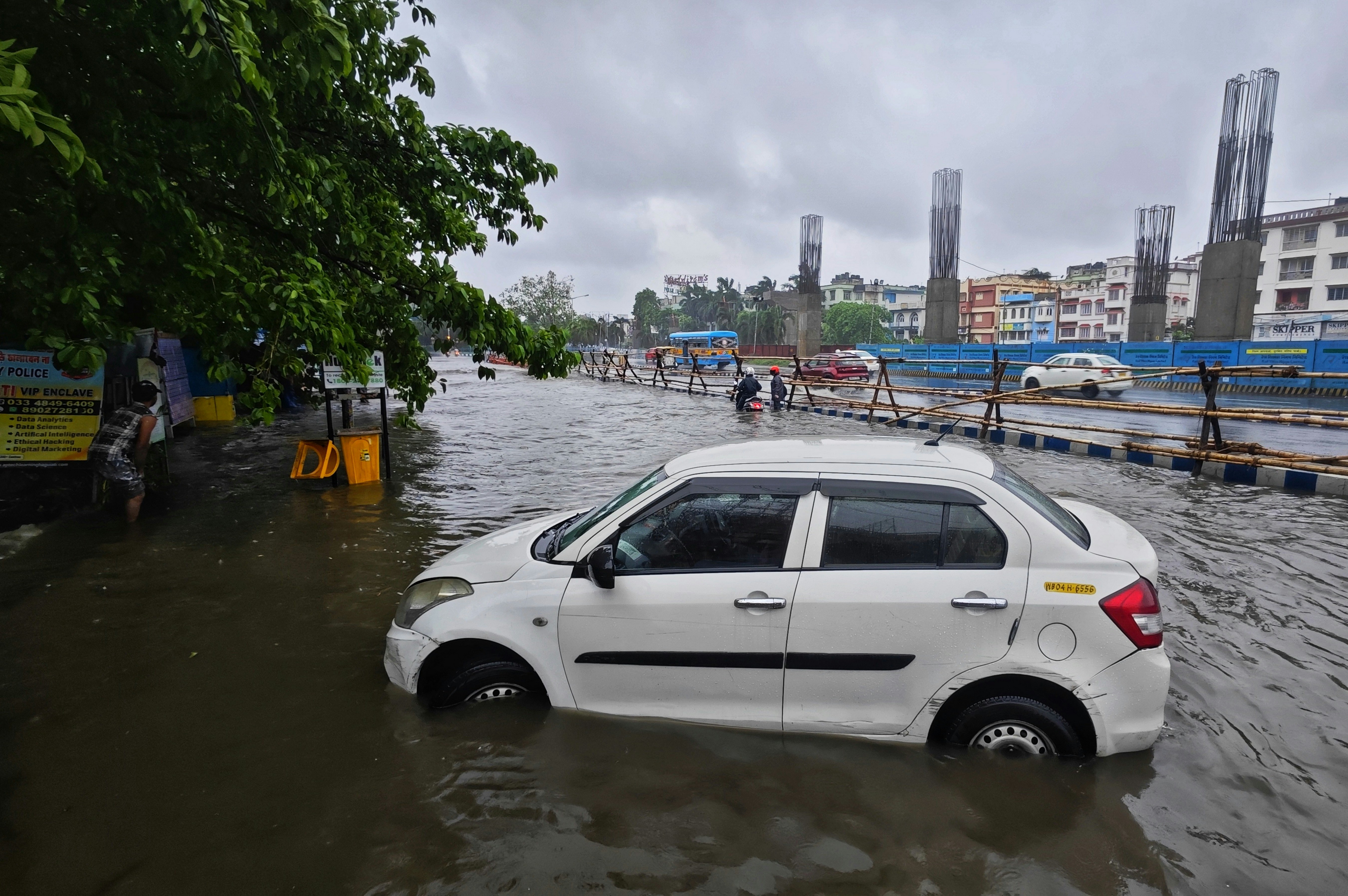 a white car driving through a flooded street