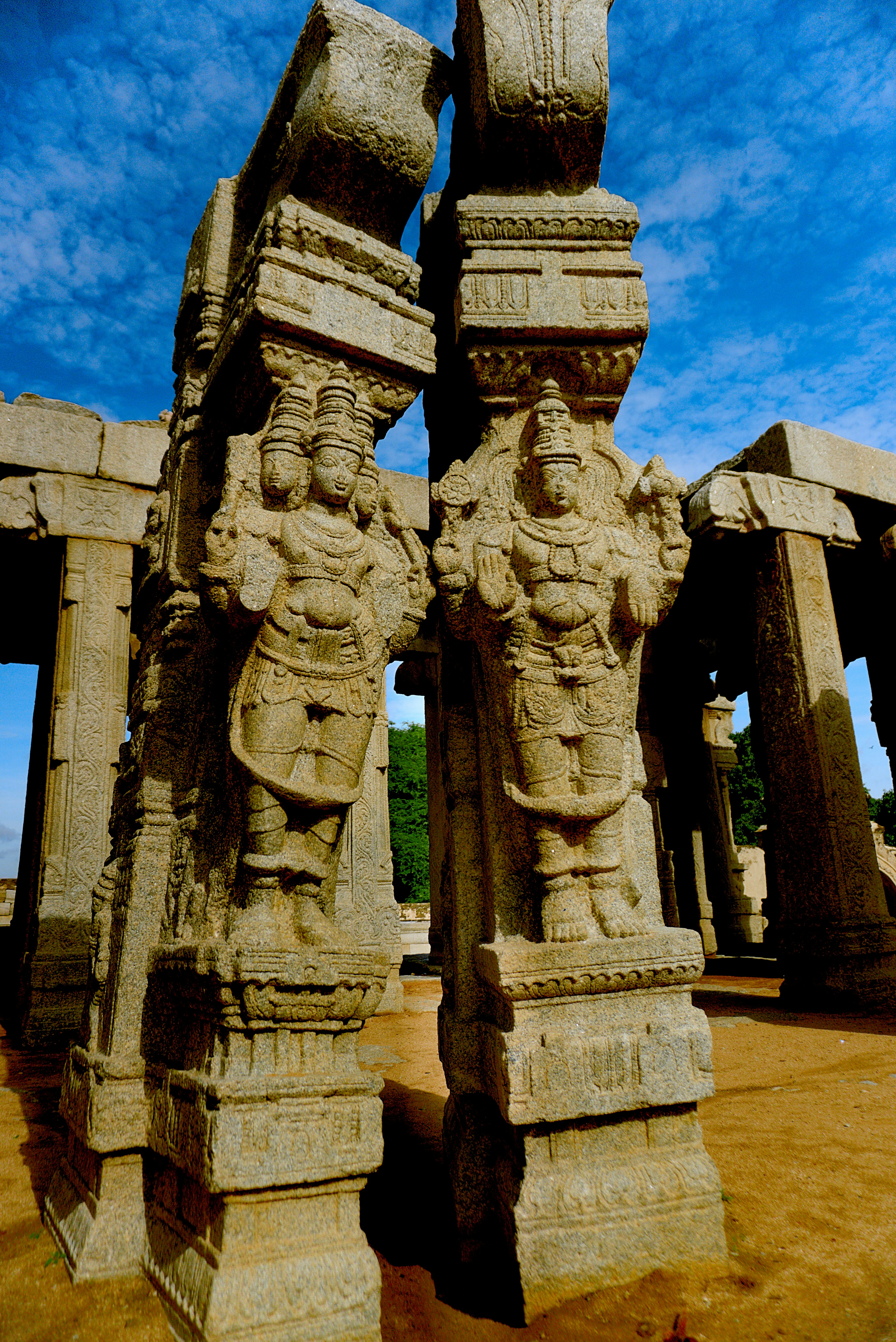 Un par de estatuas sentadas en la parte superior de un campo de tierra