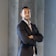a man in a suit standing with his arms crossed
