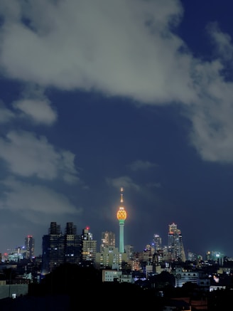 a view of a city at night with clouds in the sky
