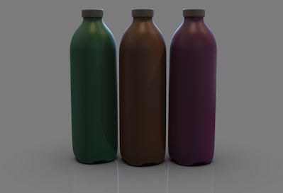 three different colored bottles sitting next to each other