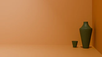 a green vase sitting next to a green cup