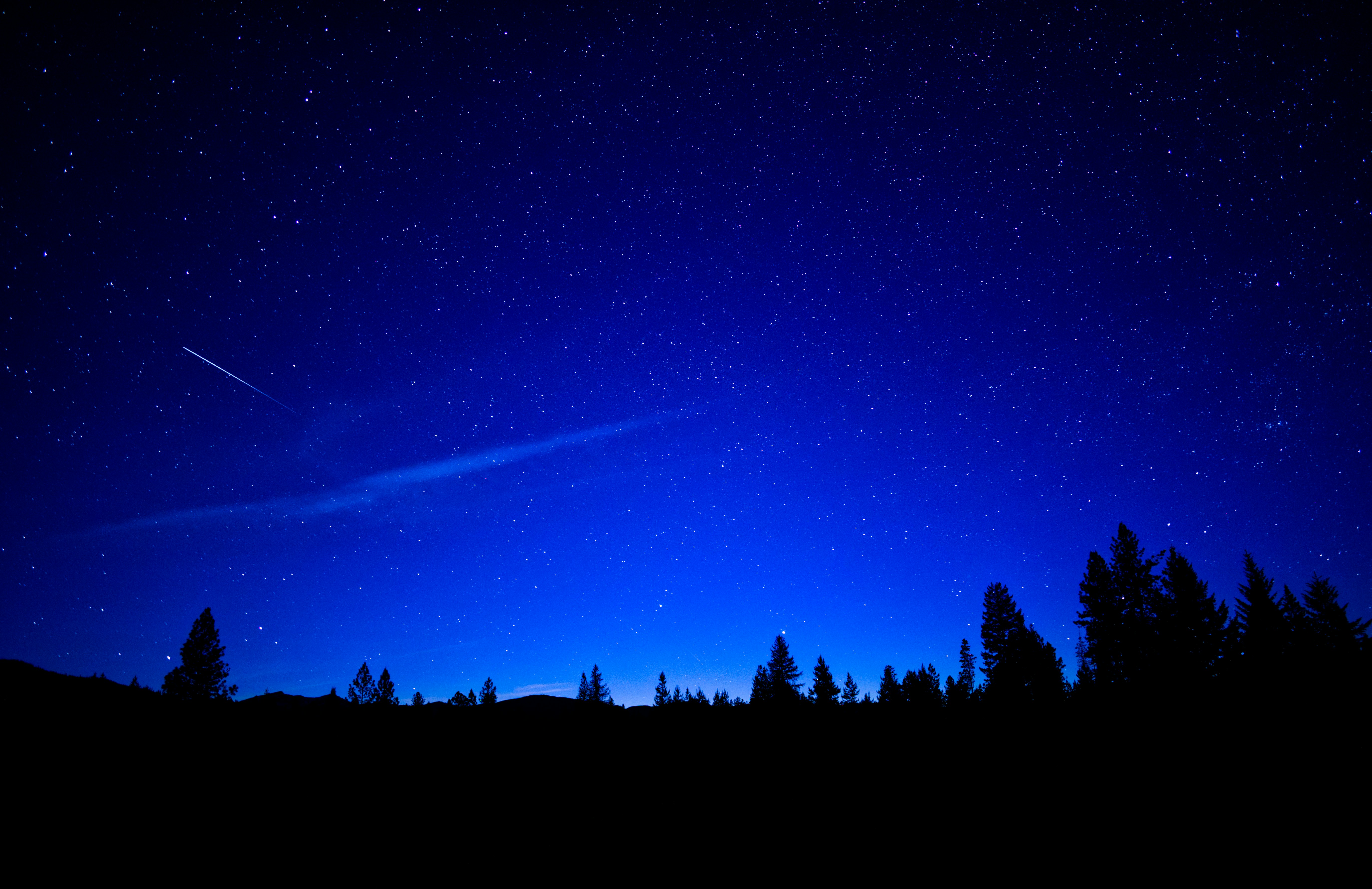 a night sky with stars and a shooting star