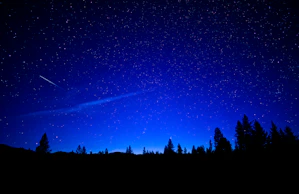 a night sky with stars and a shooting star