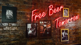 a brick wall with a neon sign that says free beer tomorrow