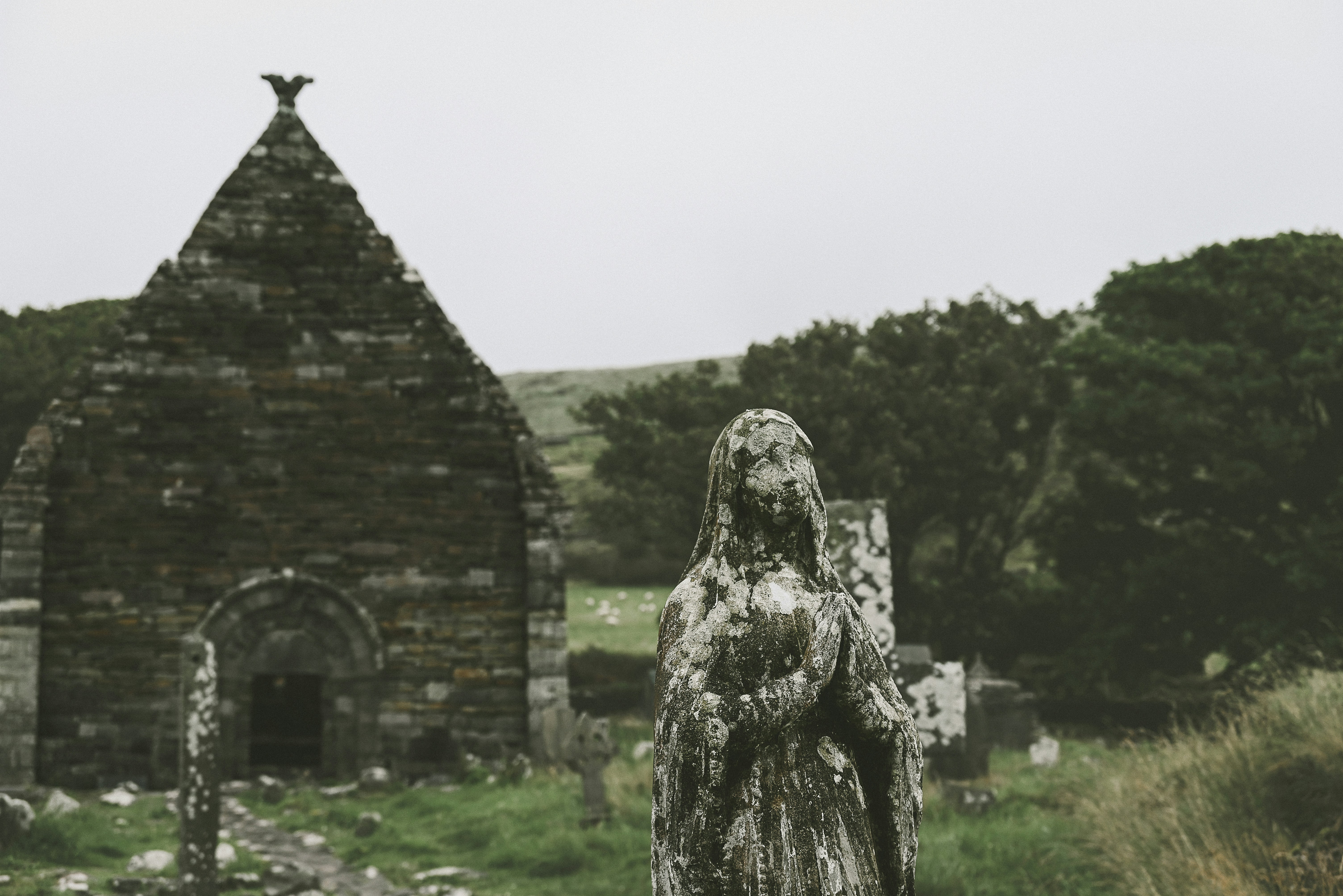 una estatua de una mujer de pie frente a una iglesia