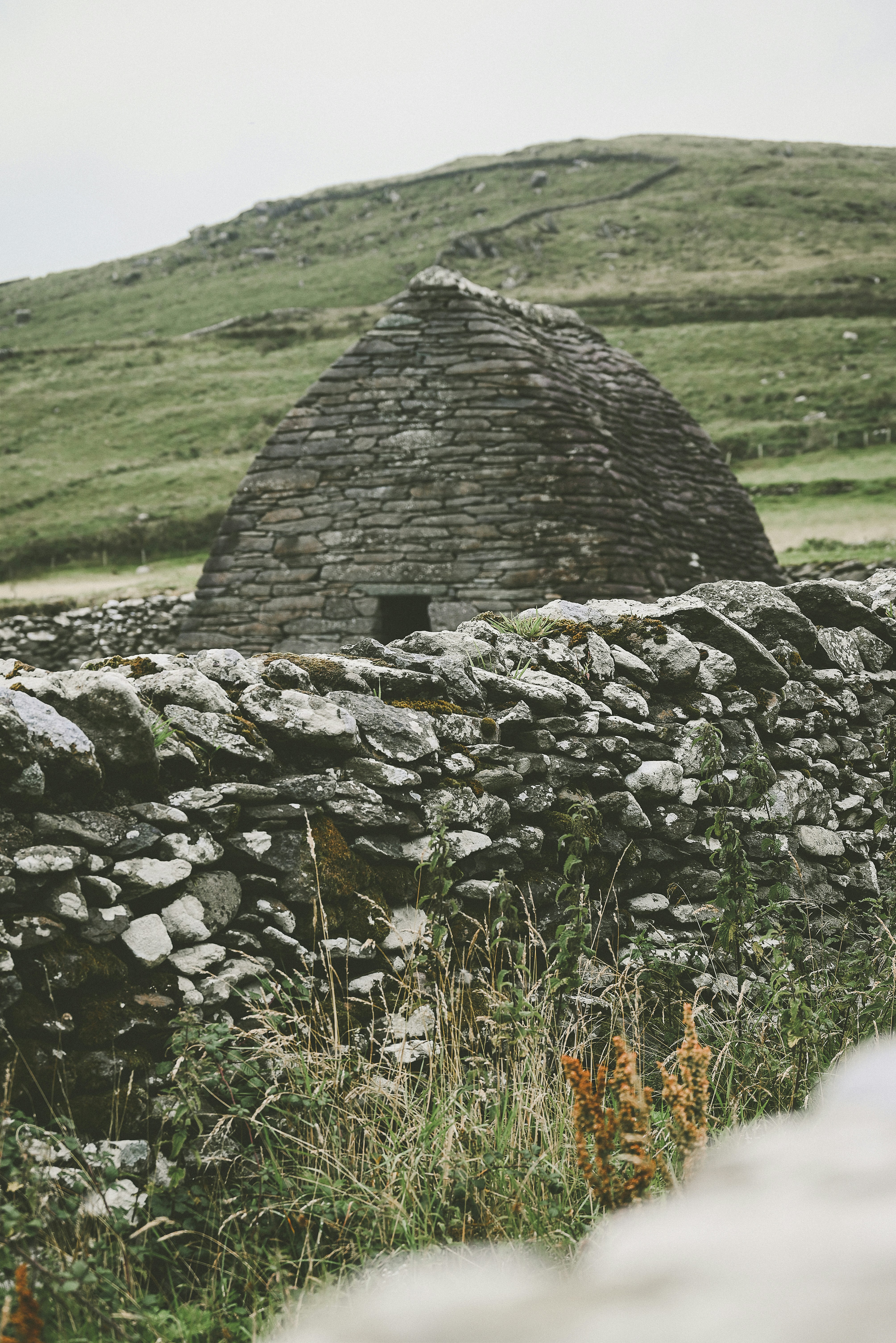a stone wall with a building in the background