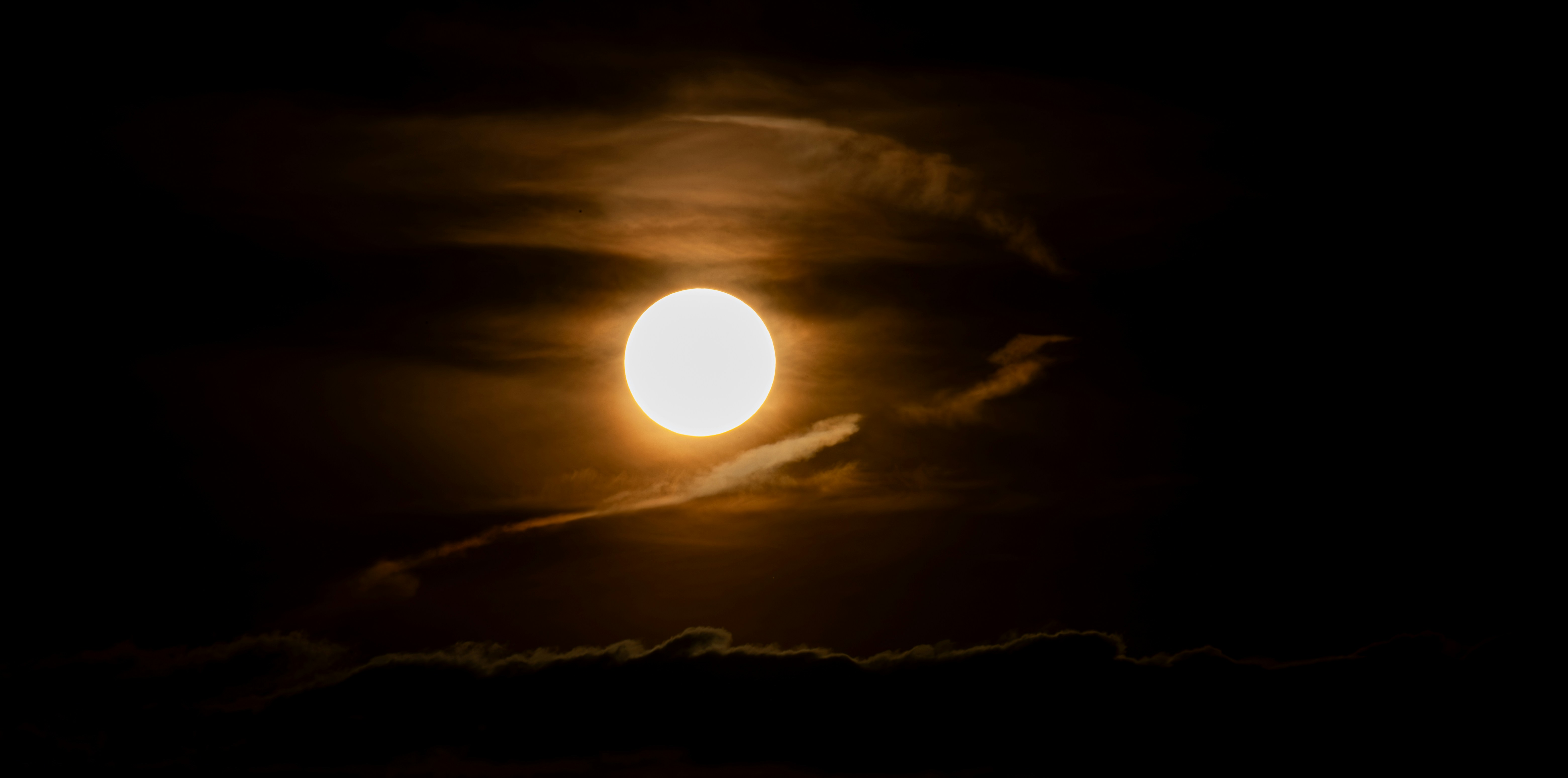 the sun is shining brightly in the dark sky