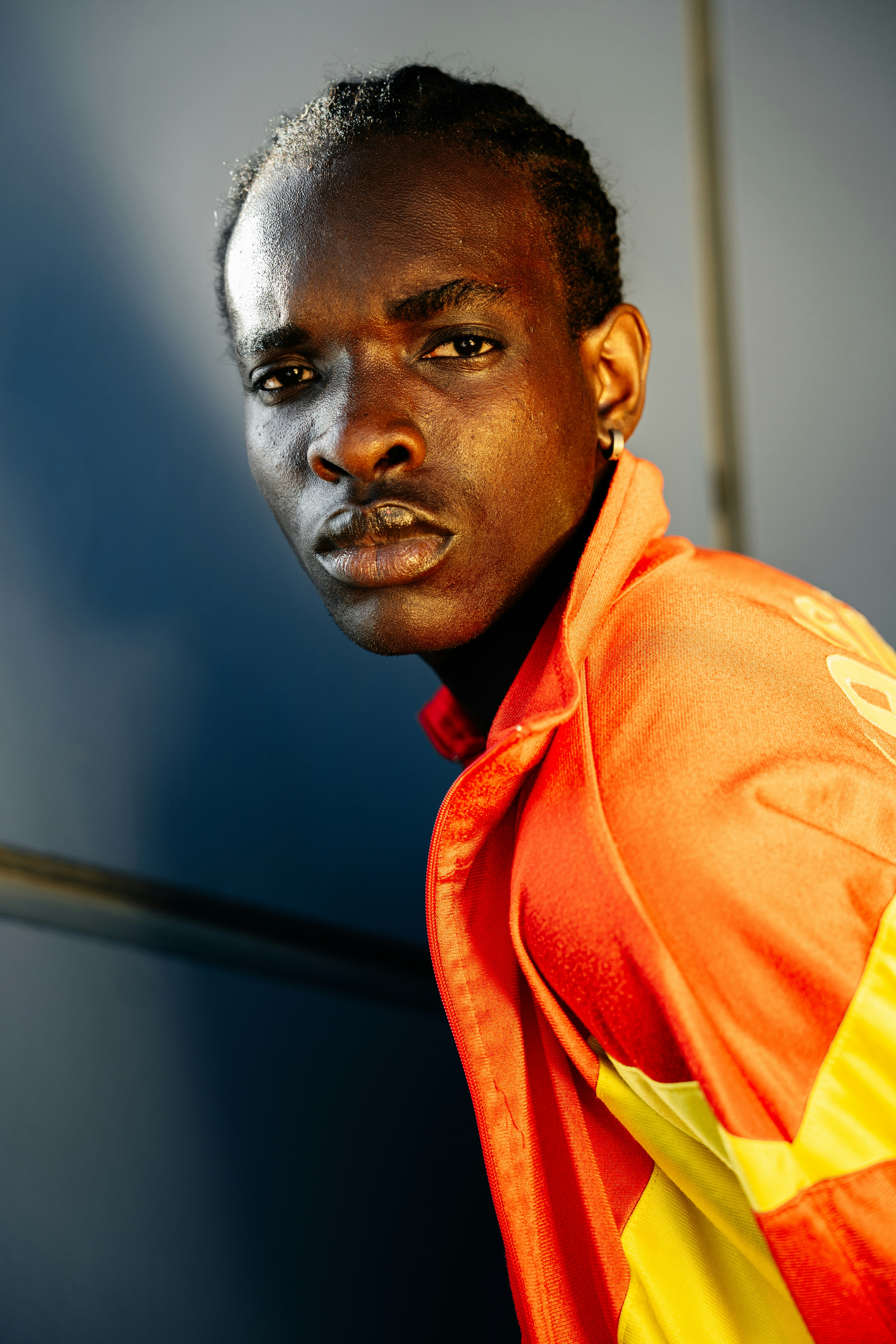 A man in an orange and yellow jacket posing for a picture photo – Free ...