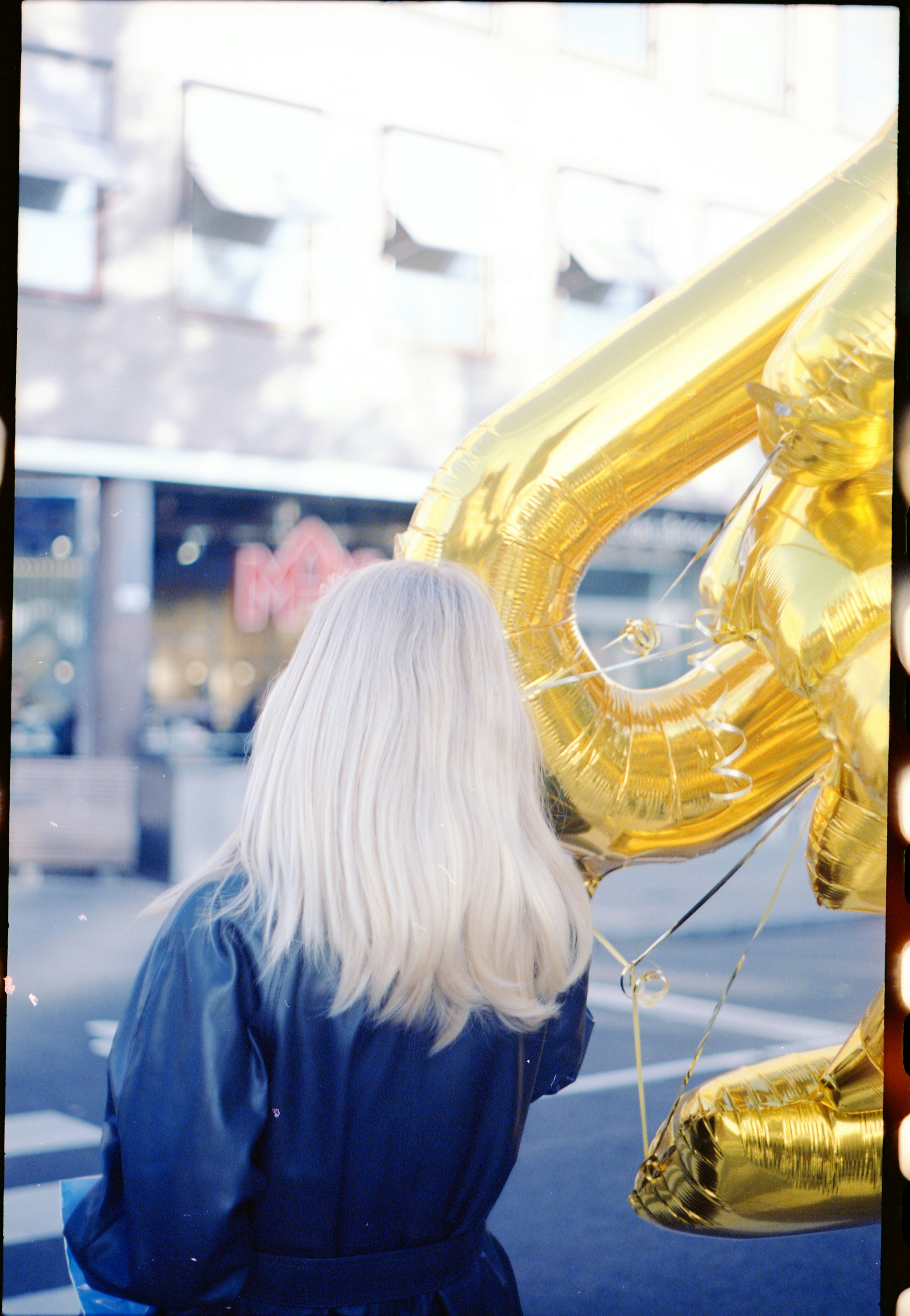 Eine Frau mit blonden Haaren steht neben einem großen Zahlenballon