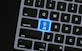 a close up of a keyboard with a blue button