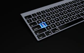 a black keyboard with a blue button on it