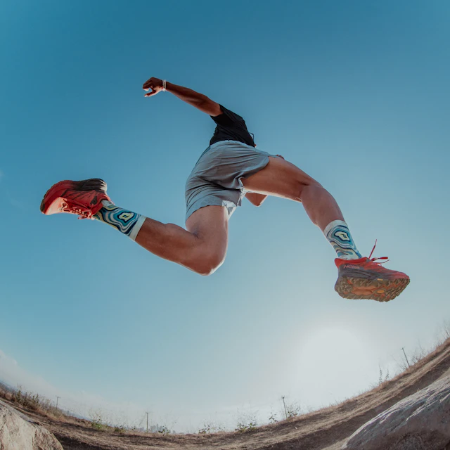 A man leaping mid stride while trail running