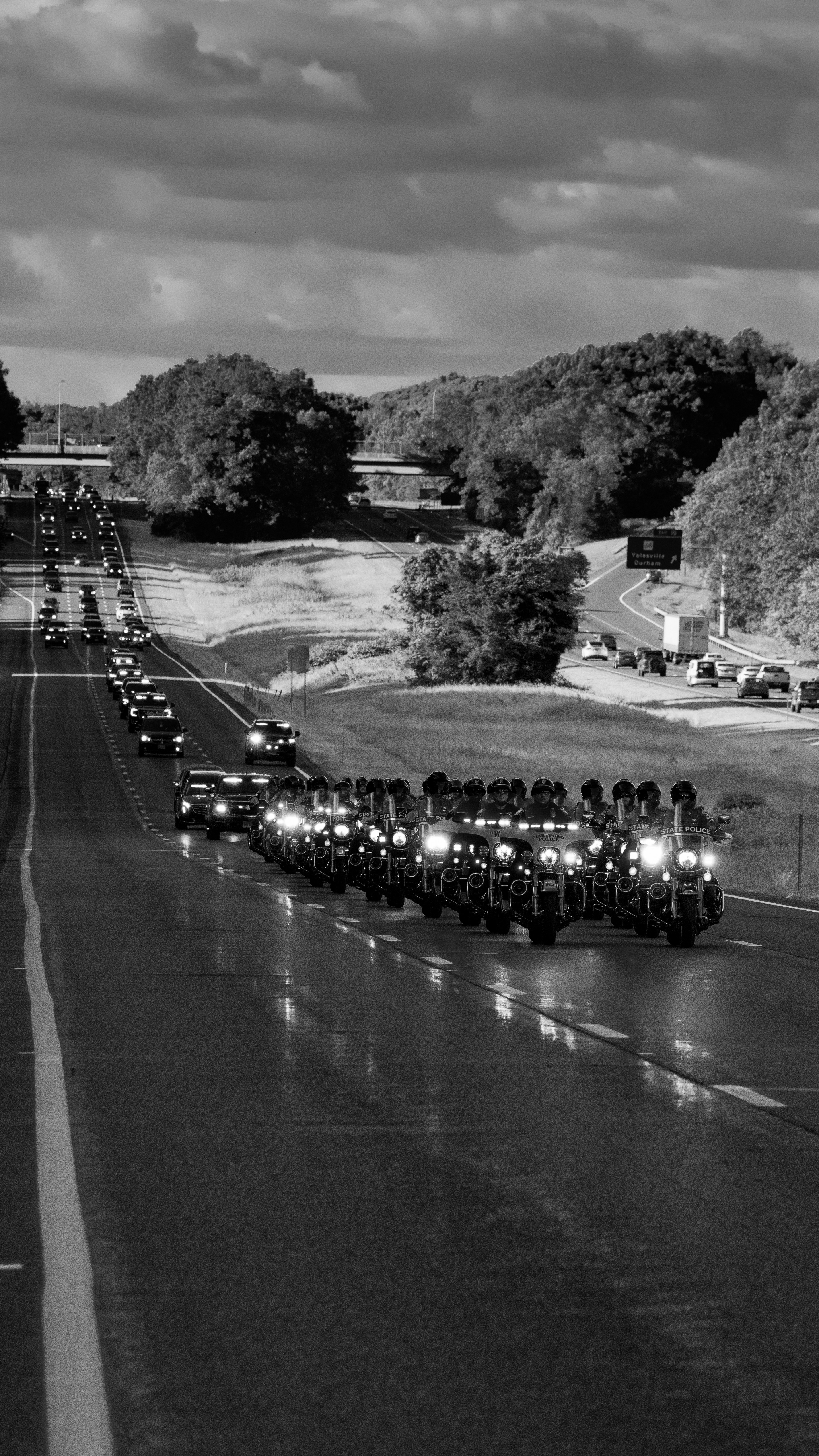 a black and white photo of a long line of motorcycles