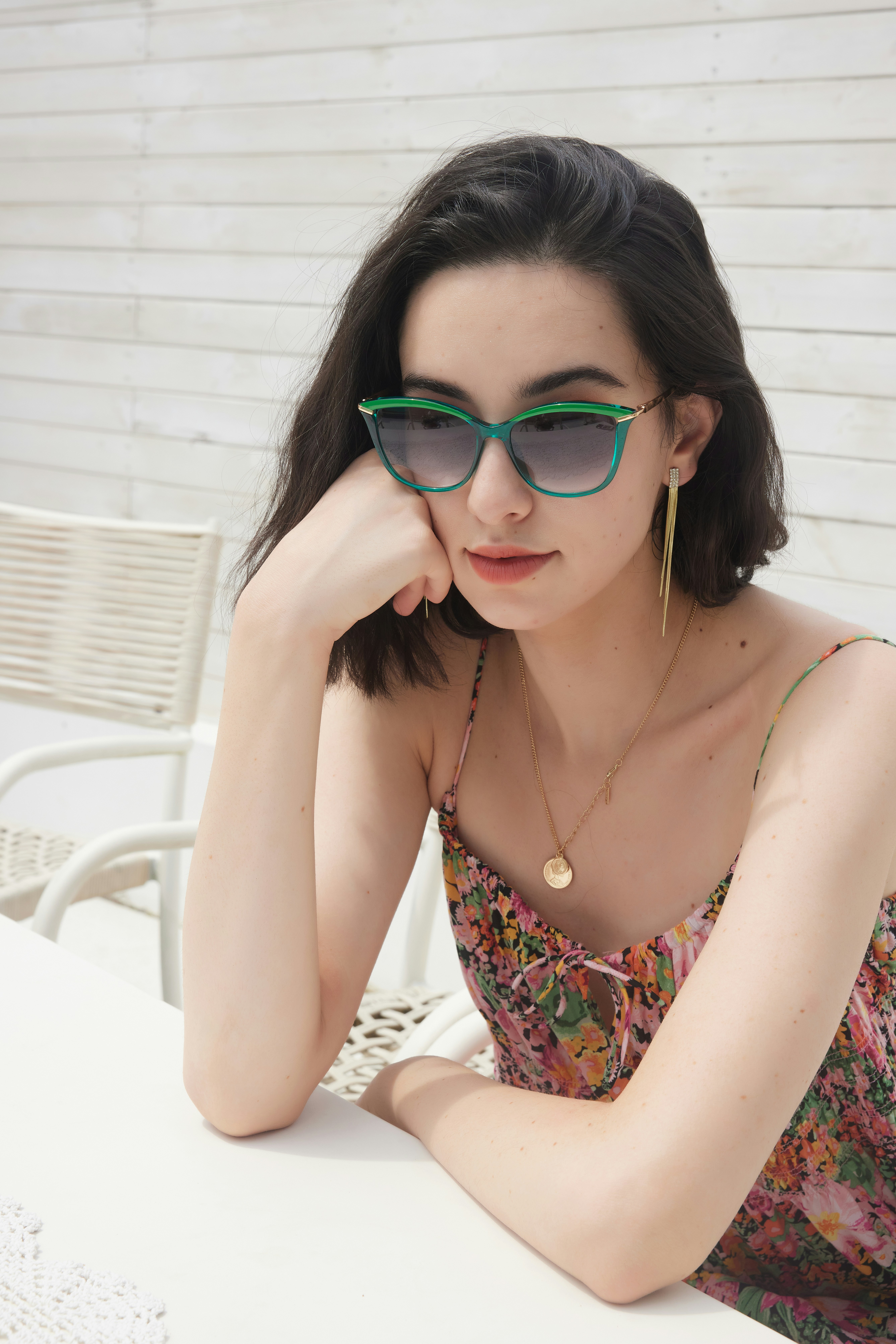 a woman sitting at a table wearing sunglasses