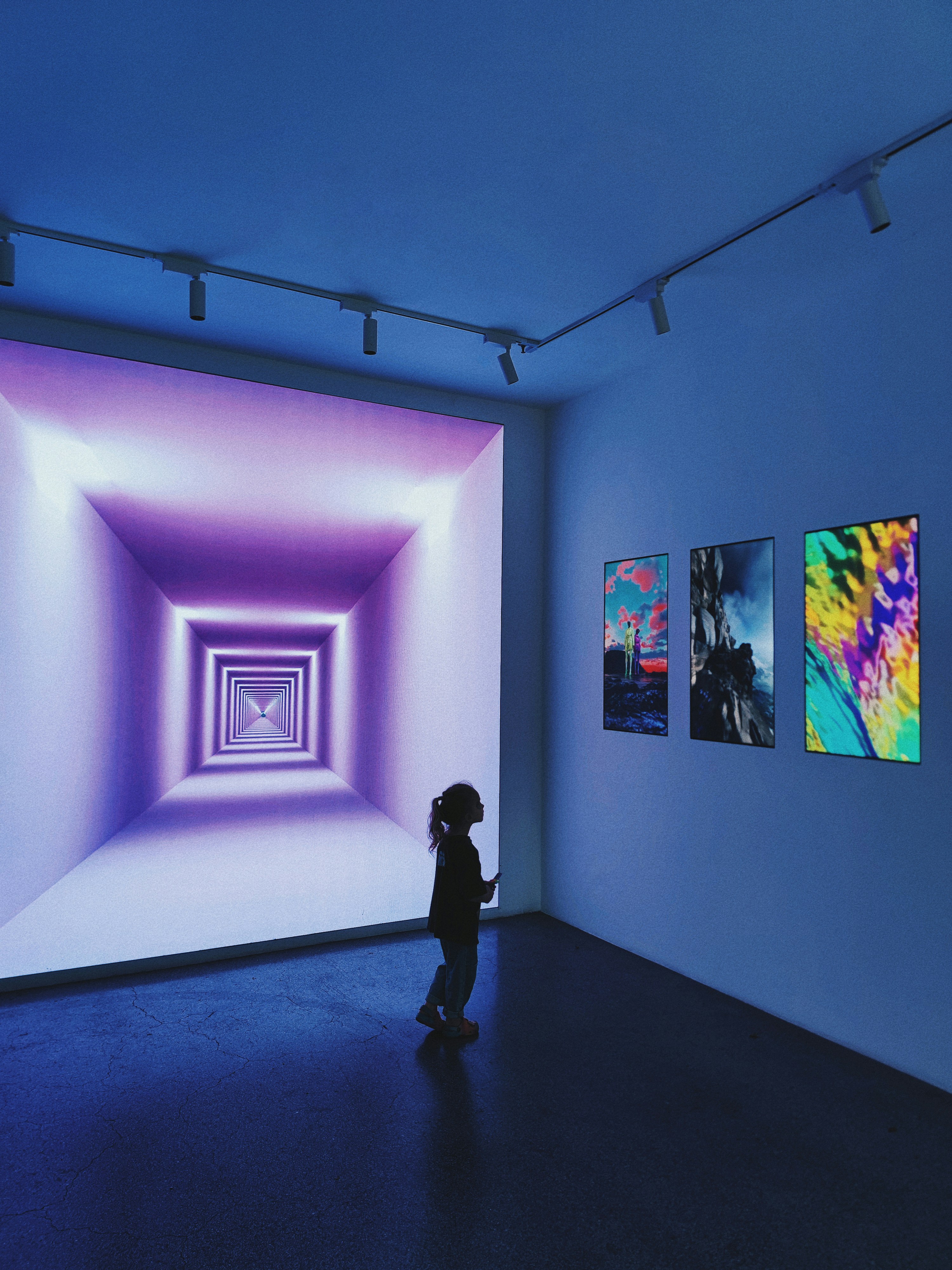 a young girl standing in a room with wall paintings