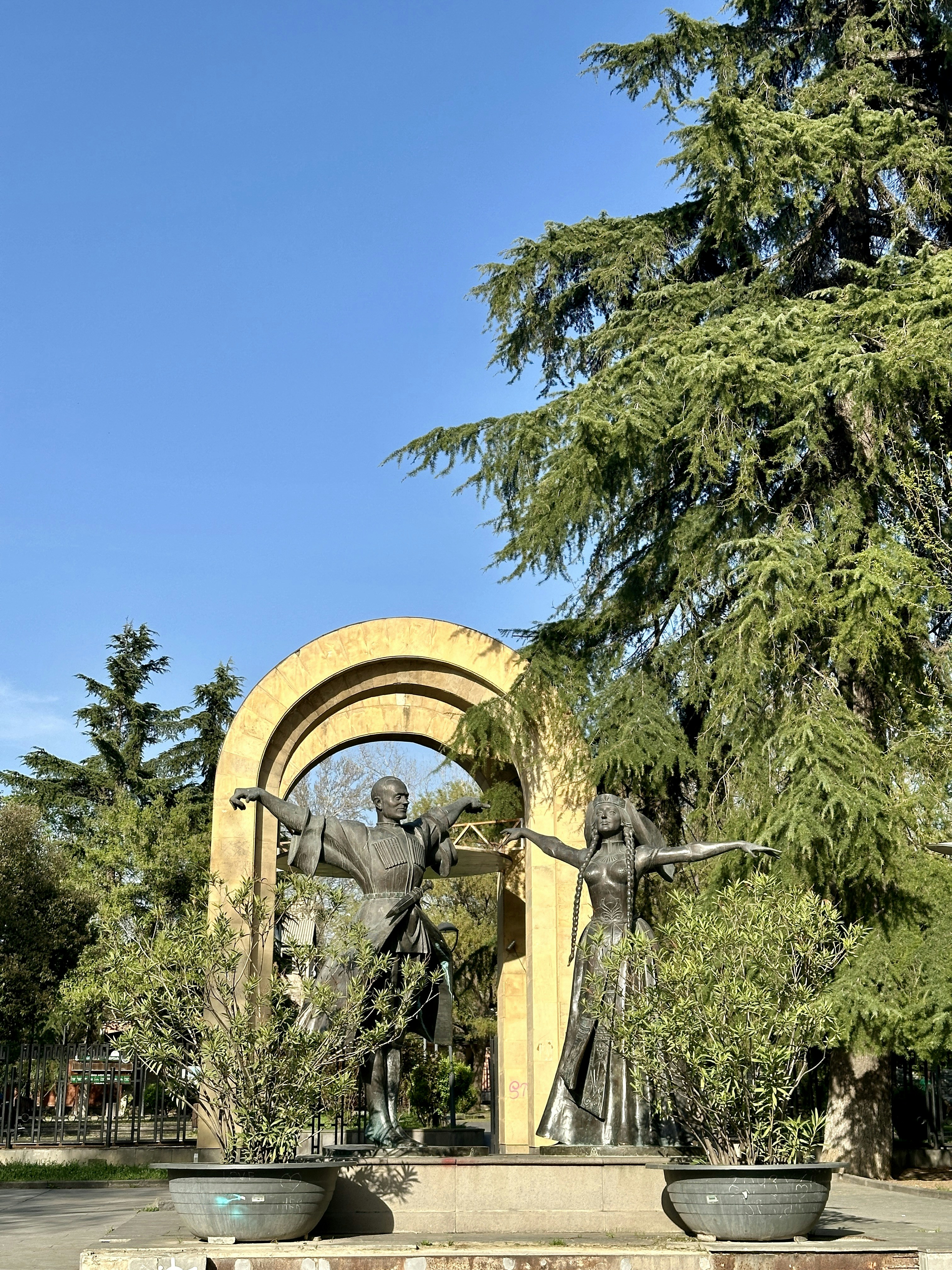 a statue of a man and a woman in a park