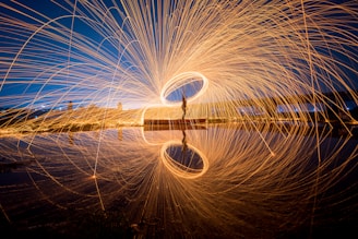 a person standing on a dock with a long exposure of light