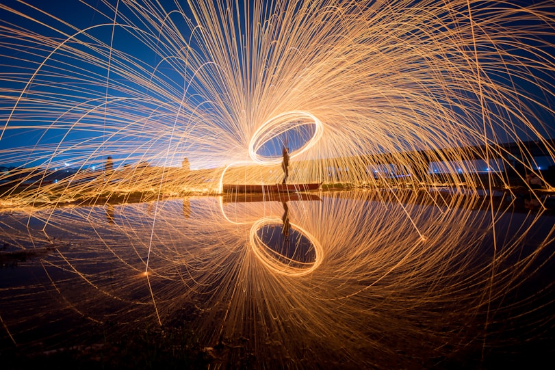 a person standing on a dock with a long exposure of light