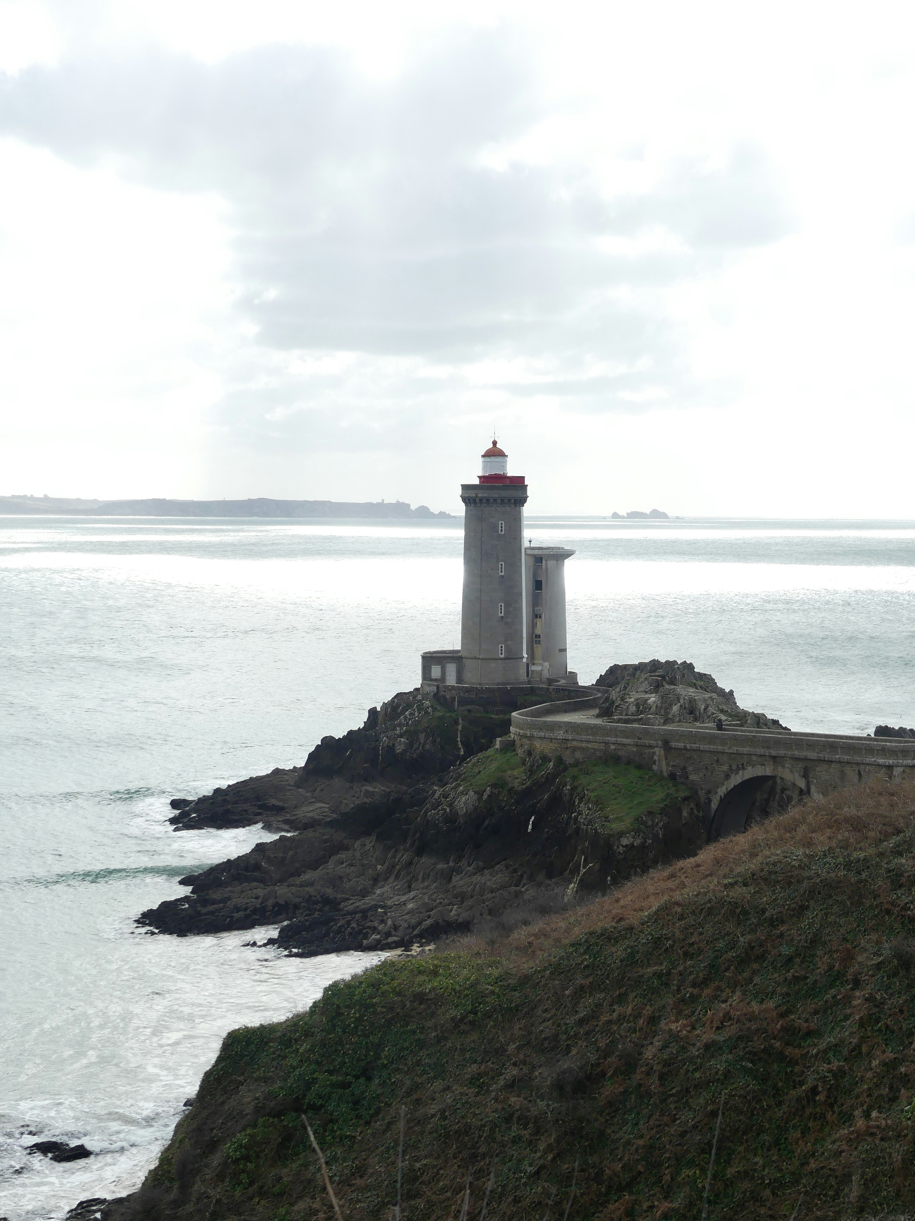 a light house sitting on top of a cliff next to the ocean