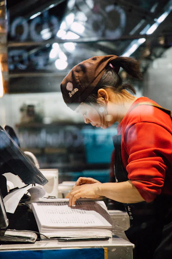 Restaurant employee reviewing records at a point-of-sale station