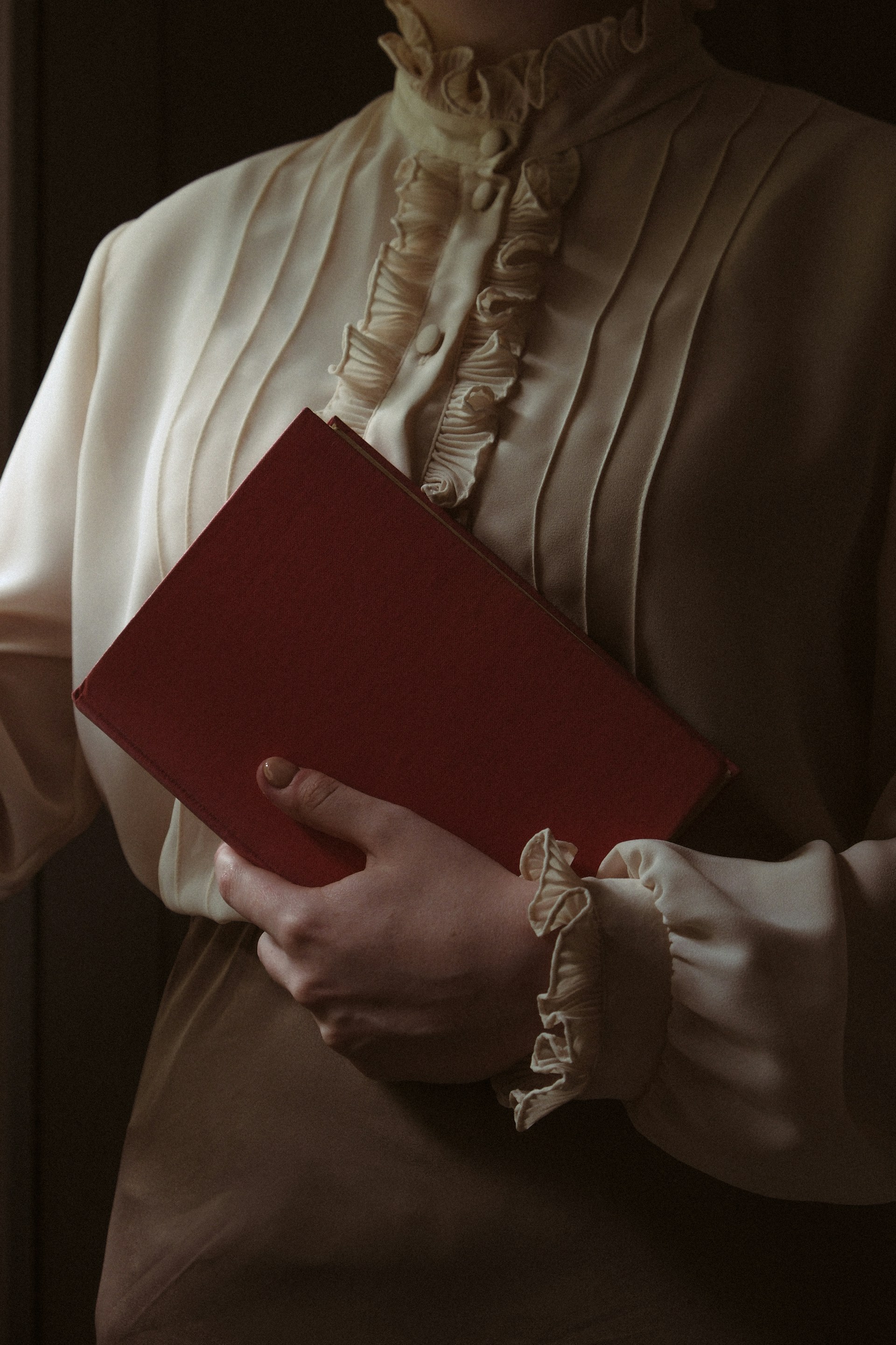 a woman holding a red book in her hands