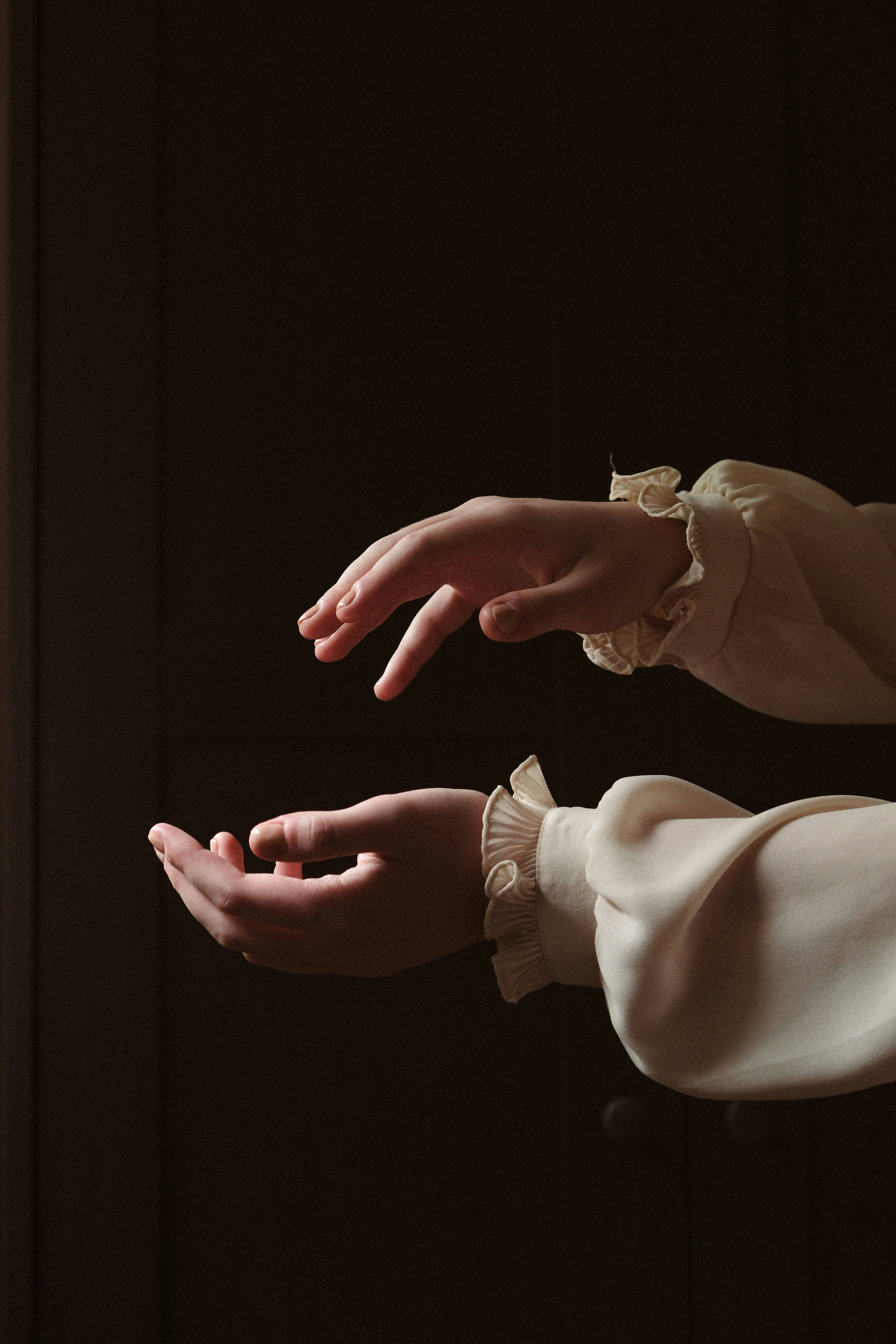 two hands reaching towards each other in the dark