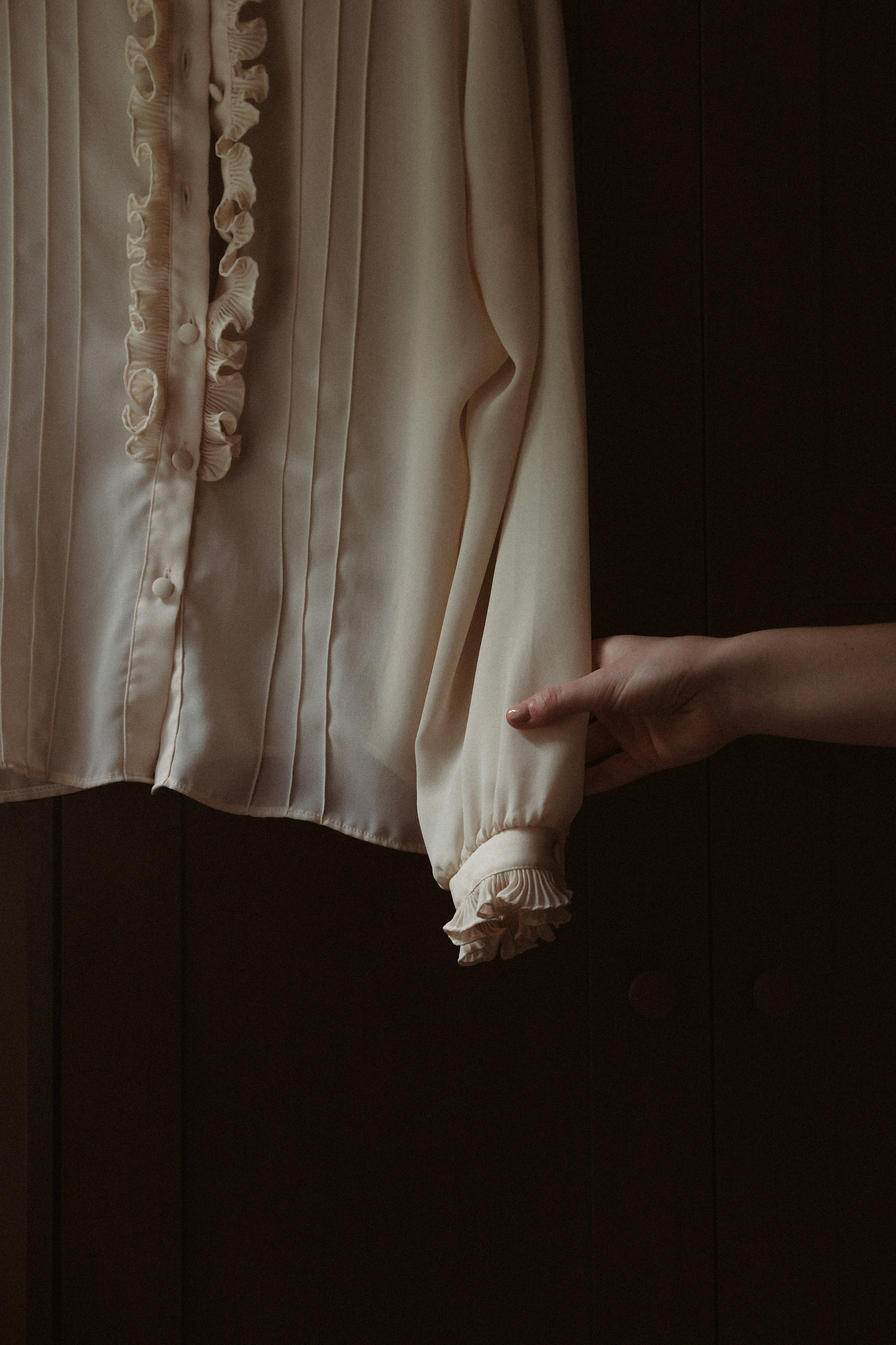 A woman's hand holding a white blouse with ruffles photo – Free Hand ...