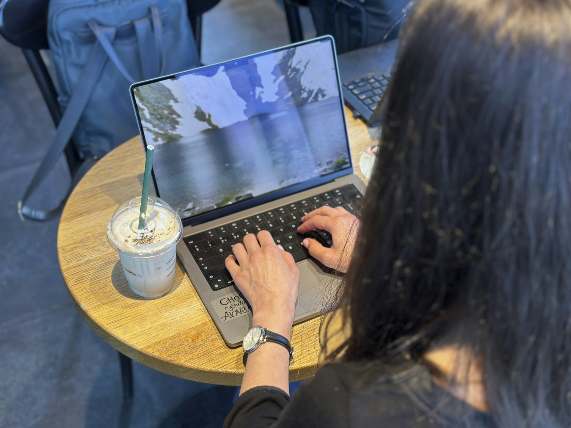 a woman sitting at a table using a laptop computer