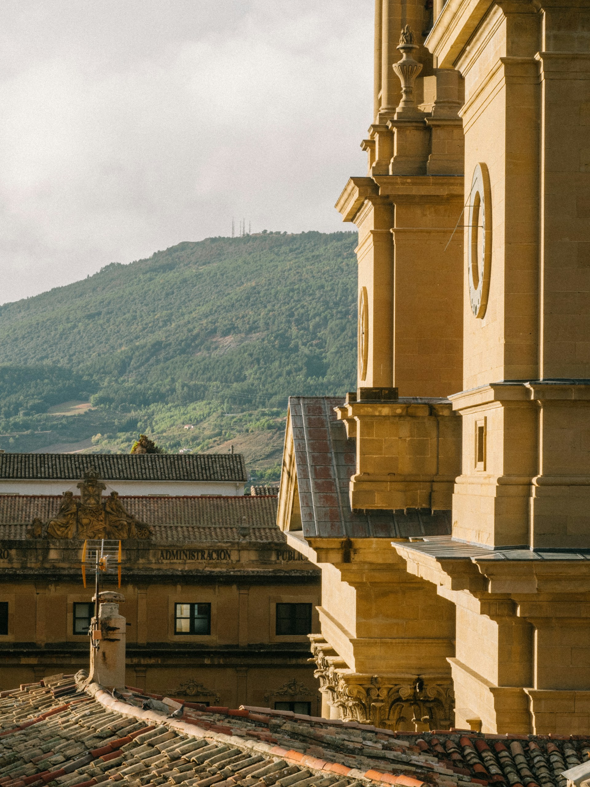 a clock on the side of a building with mountains in the background