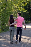a man and a woman walking down a dirt road