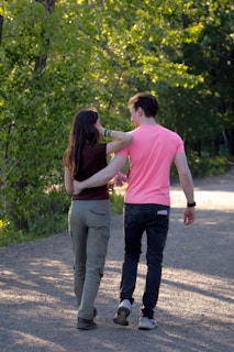 a man and a woman walking down a dirt road