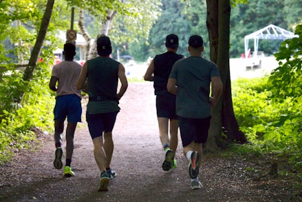 a group of people running down a dirt road