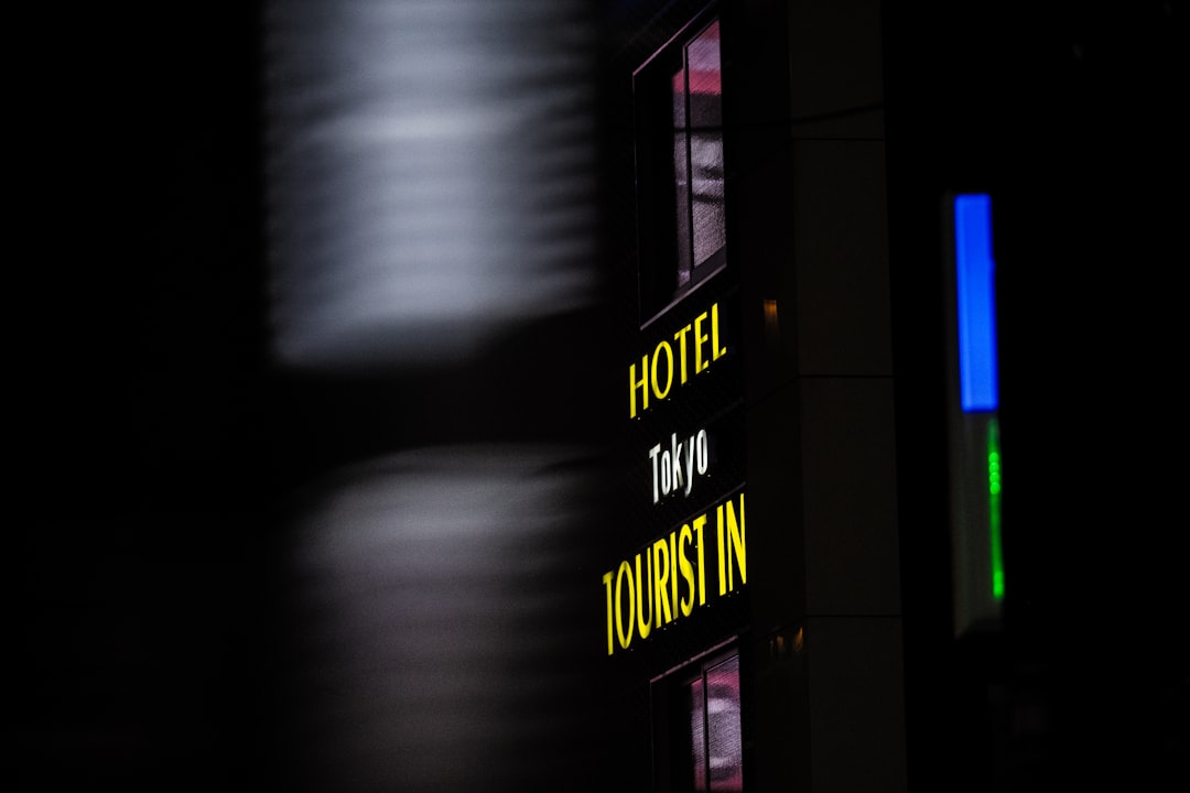 a hotel sign is lit up in the dark, HOTEL