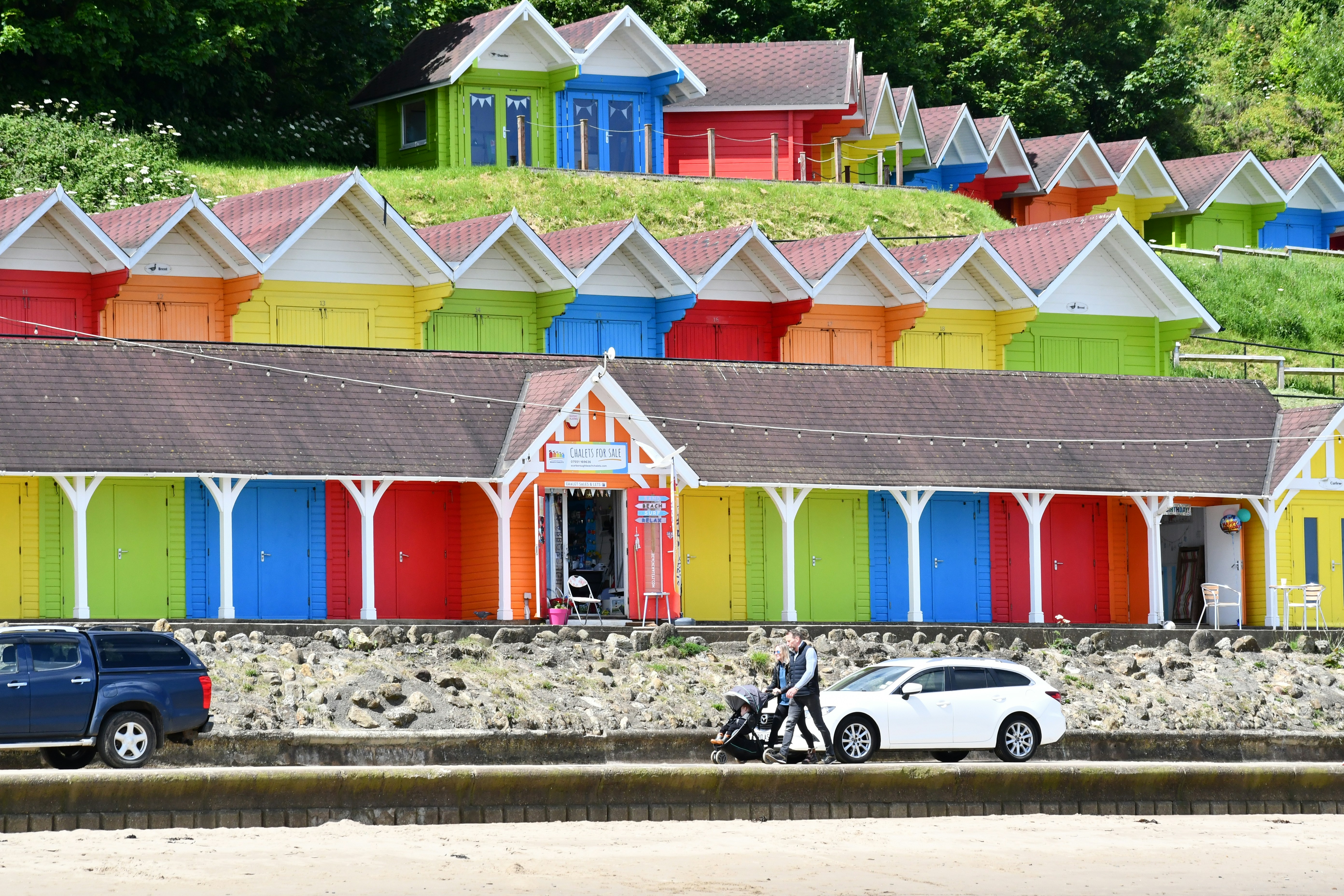una fila di case multicolori con un'auto parcheggiata davanti a loro