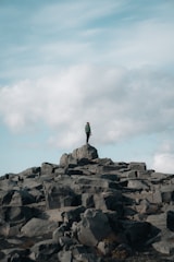 a man standing on top of a large pile of rocks
