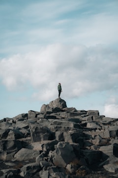 a man standing on top of a large pile of rocks