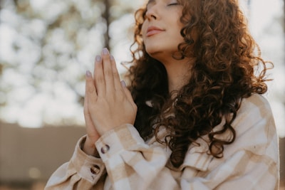 a woman with her hands folded in prayer