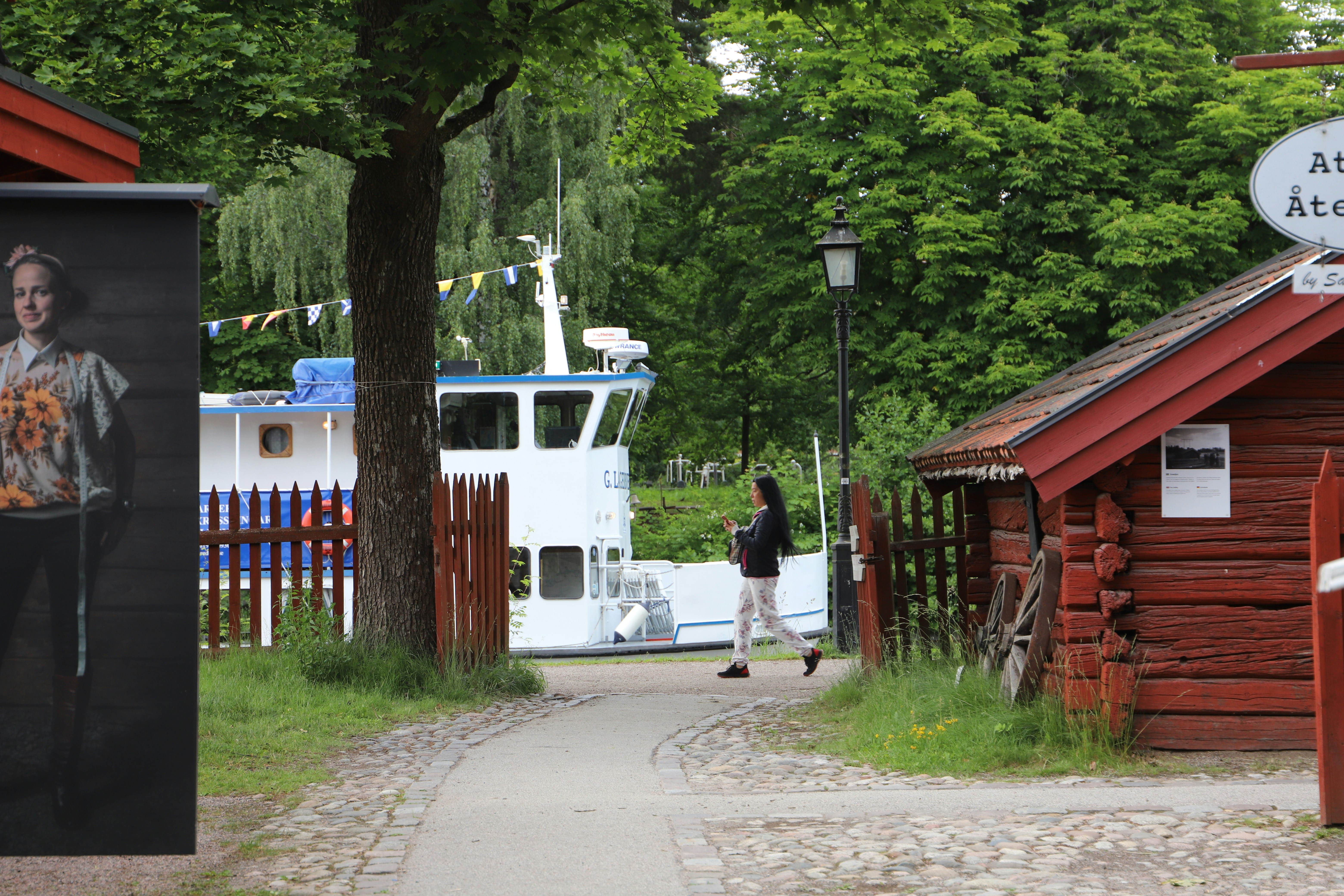 a man walking down a sidewalk next to a red building