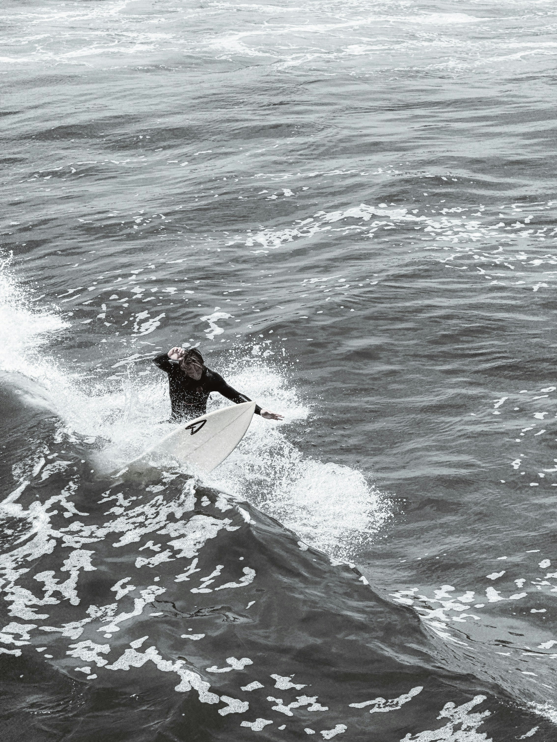 A man riding a surfboard on top of a wave in the ocean photo – Free ...