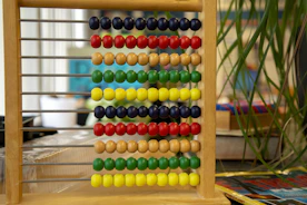 a wooden abacusk sitting on top of a table next to a plant