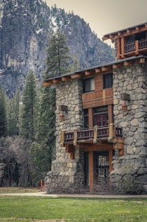 a stone and wood building with a mountain in the background