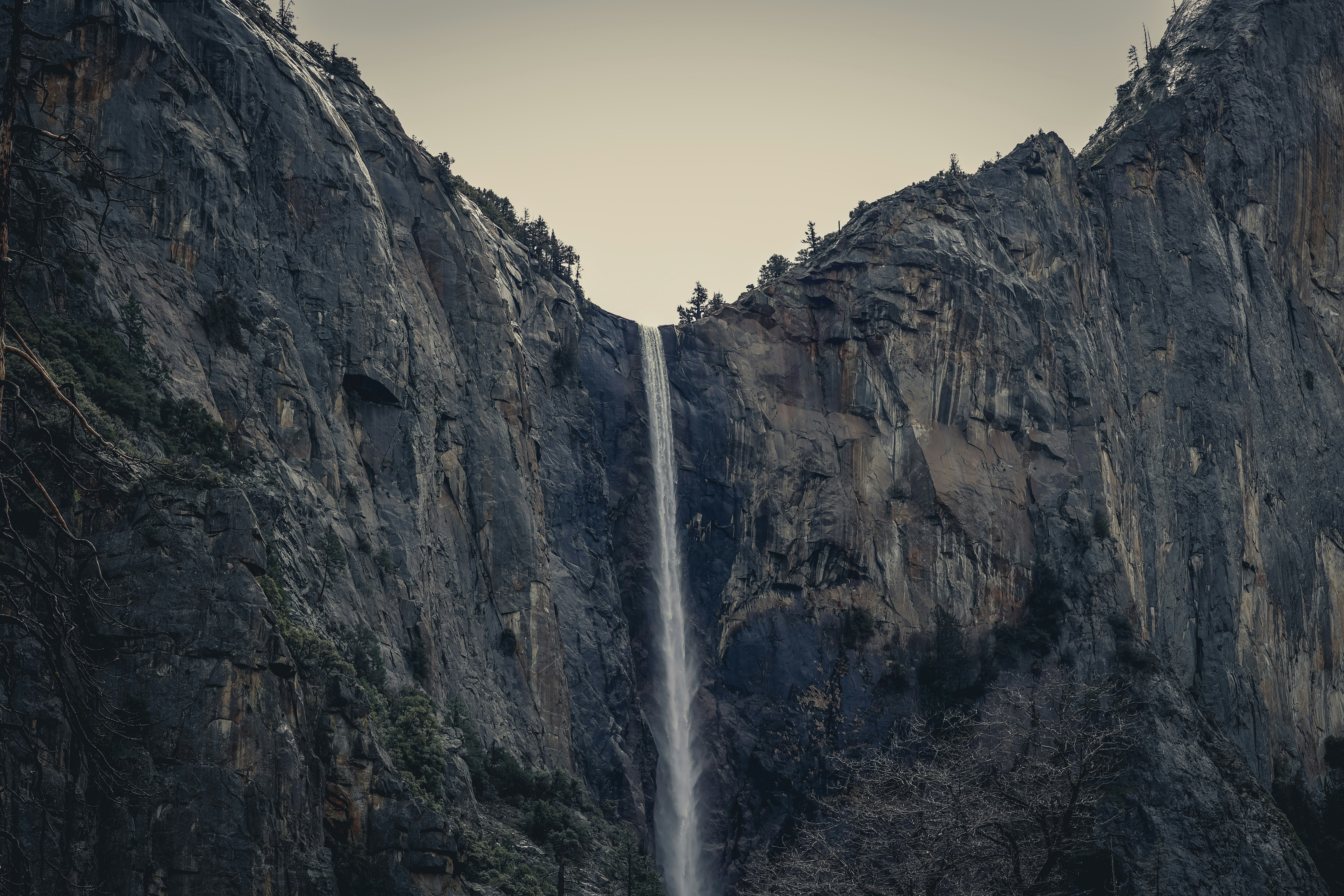 a tall waterfall in the middle of a mountain