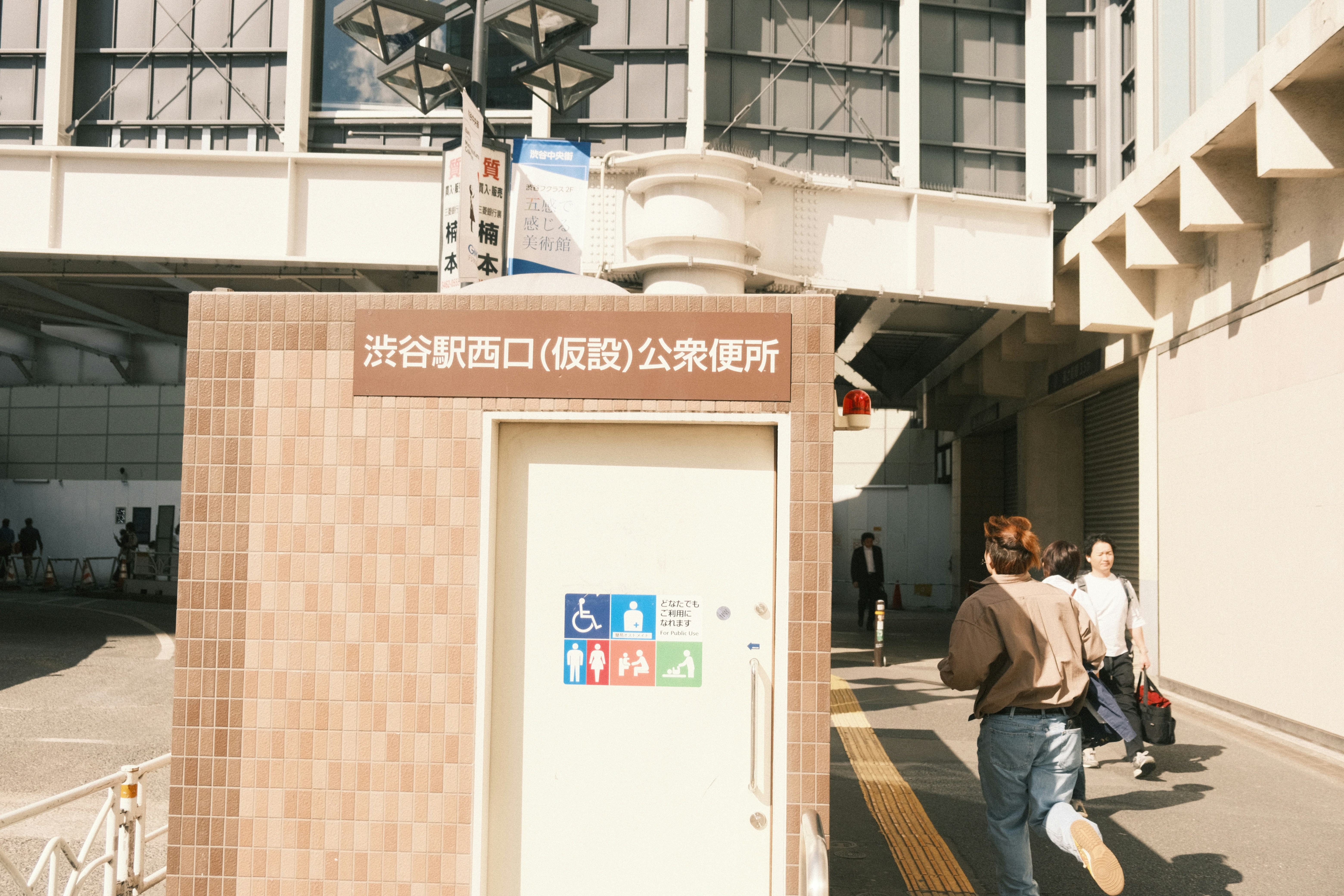 a group of people walking down a street next to a tall building