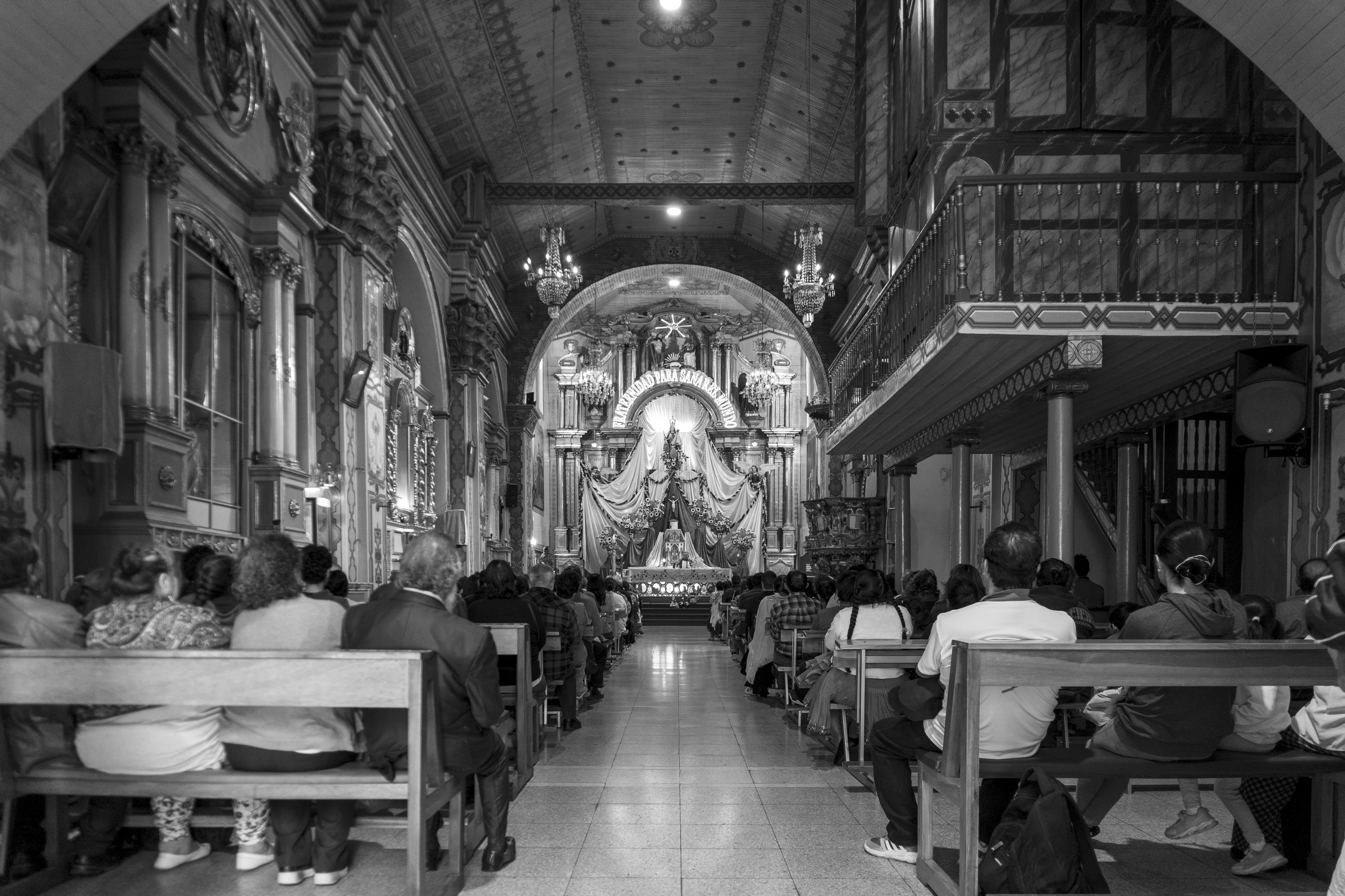 a black and white photo of people in a church